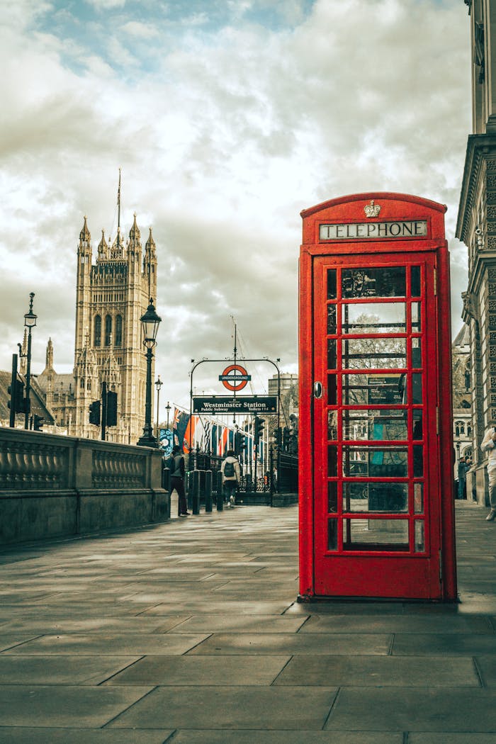 A classic red telephone booth on a London street near Westminster, capturing British charm.